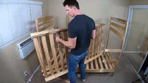 man carrying a large disassembled bunk bed side panel, face visible